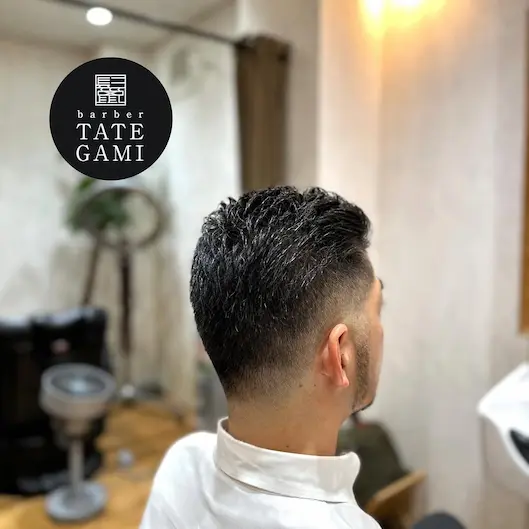 Client sitting in the barber chair with a fresh fade and clean style
