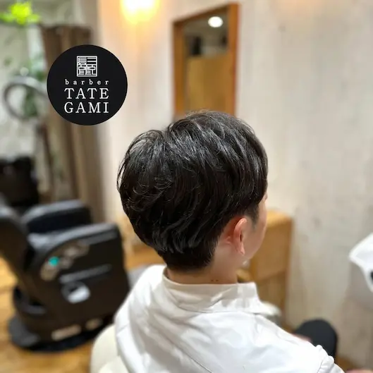 Client sitting in the barber chair with a fresh fade and clean style