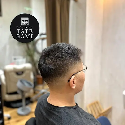 Client sitting in the barber chair with a fresh fade and clean style