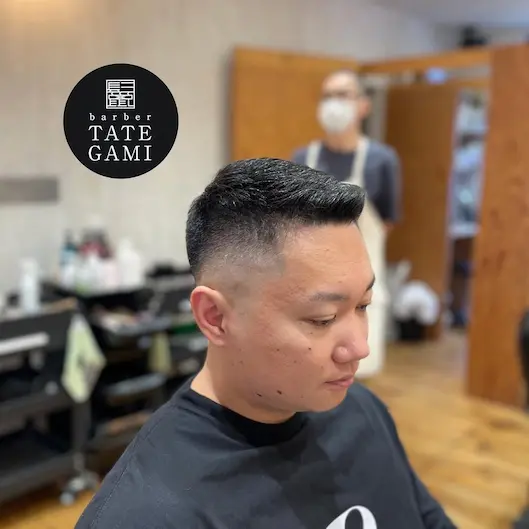 Client sitting in the barber chair with a fresh fade and clean style