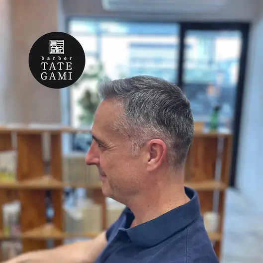 Client sitting in the barber chair with a fresh fade and clean style