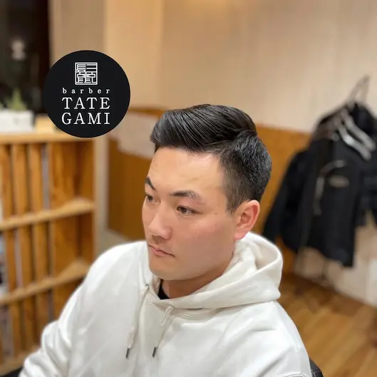 Client sitting in the barber chair with a fresh fade and clean style