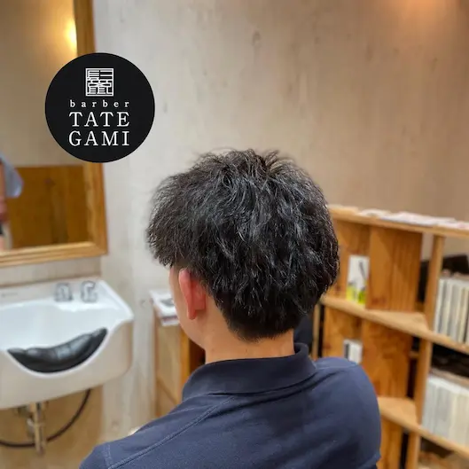 Client sitting in the barber chair with a fresh fade and clean style