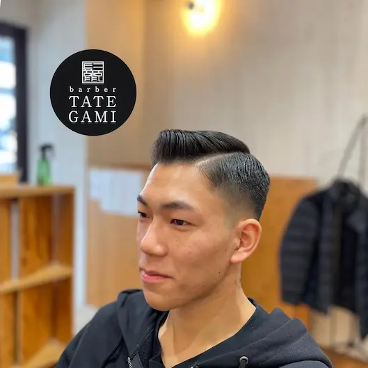 Client sitting in the barber chair with a fresh fade and clean style