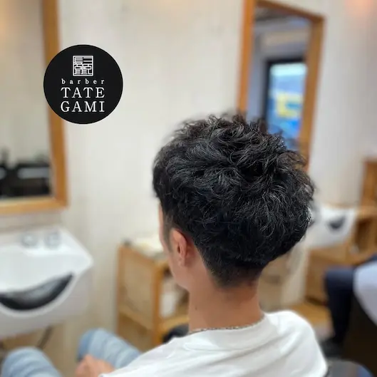 Client sitting in the barber chair with a fresh fade and clean style