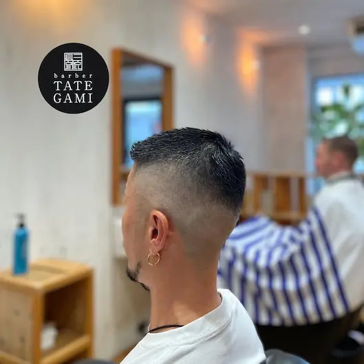 Client sitting in the barber chair with a fresh fade and clean style